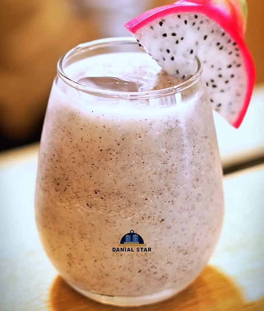 Creamy dragon fruit smoothie garnished with a fresh slice, served in a glass at Danial Star Restaurant