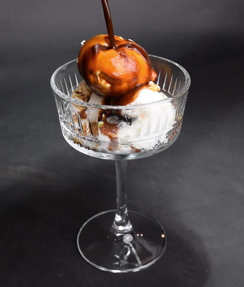 Vanilla ice cream scoop topped with rich chocolate sauce served in a glass dessert cup at Danial Star Restaurant