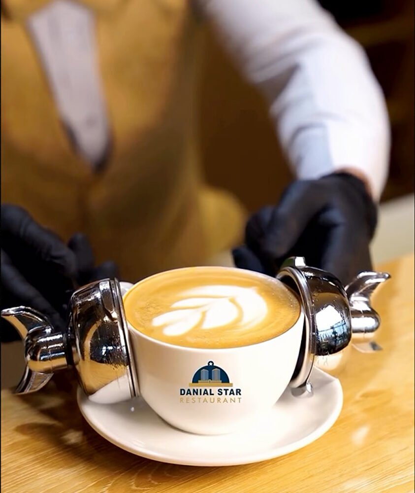 Fresh latte coffee with latte art served in a branded cup at Danial Star Restaurant