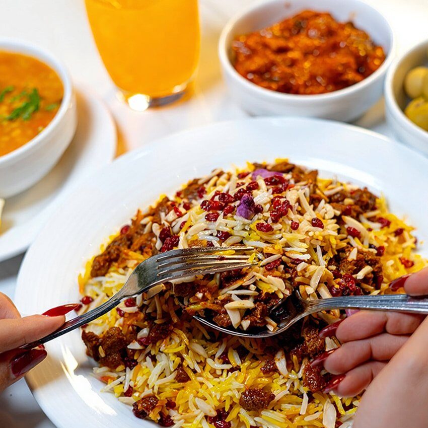 Saffron basmati rice topped with barberries and minced meat, served with sides and fresh juice at Danial Star Restaurant
