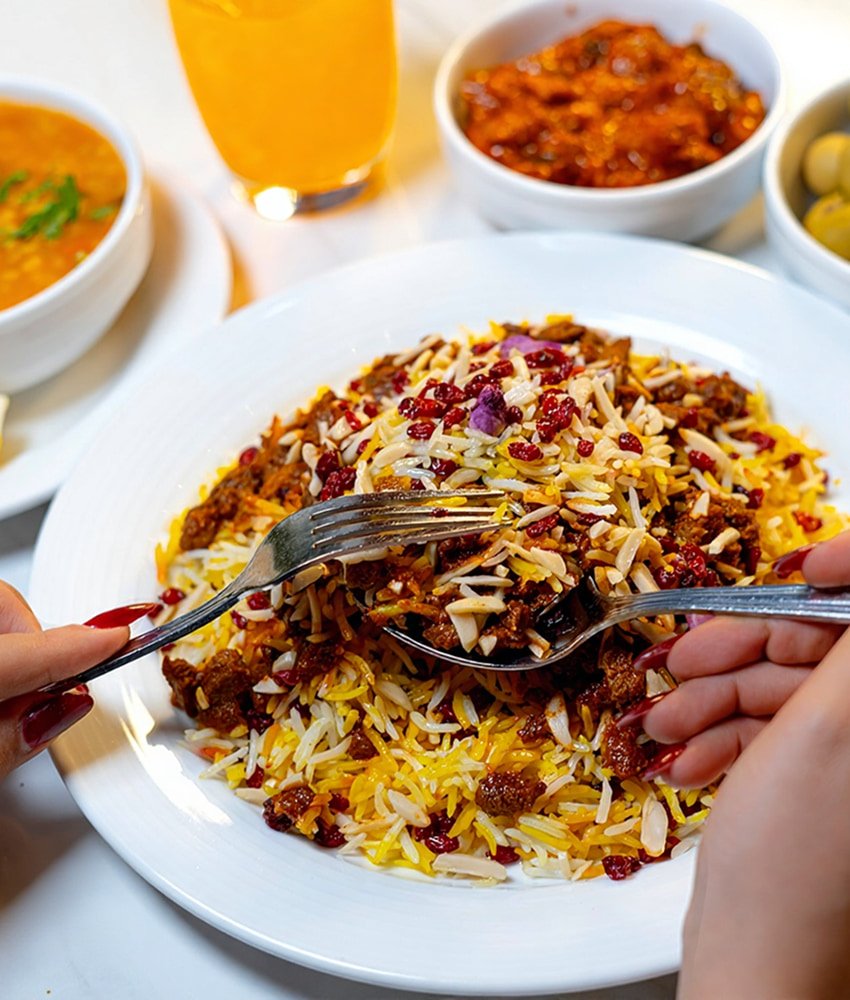 Saffron basmati rice topped with barberries and minced meat, served with sides and fresh juice at Danial Star Restaurant