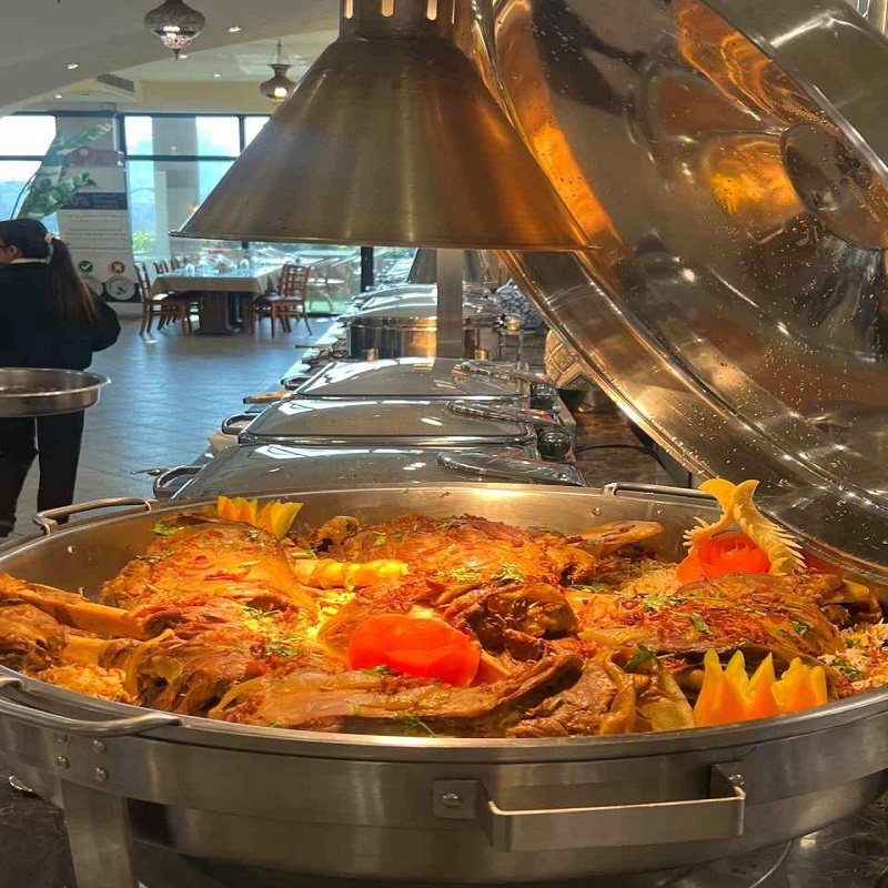 Large serving tray of traditional lamb ouzi with rice at a restaurant buffet in Dubai